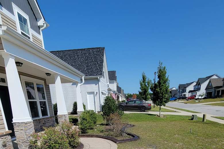 Stamped concrete curbing edging a front lawn bed at a two-storey home near Fayetteville, NC