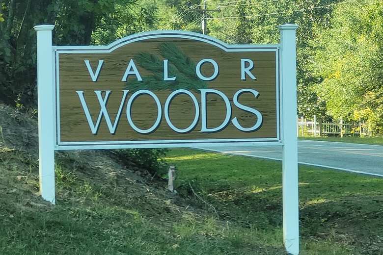 Concrete landscape curbing installed around the Valor Woods neighborhood entrance sign