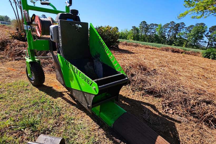 The Killer Curbz curbing machine set up on a Fayetteville, NC job site ready to extrude a new run of curb